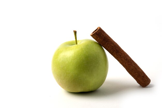 Una manzana verde con una rama de canela alrededor.