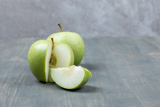 Manzana verde en rodajas aislado en una mesa de madera