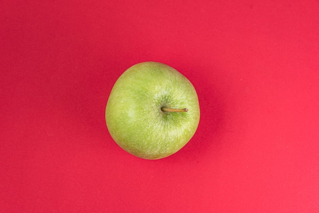 Foto gratuita manzana verde sobre rojo