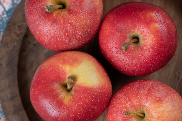 Manzanas aisladas en una bandeja de madera rústica