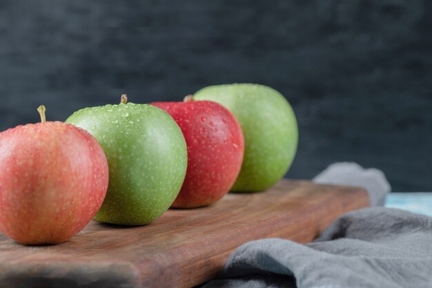 Manzanas aisladas sobre una tabla de cortar de madera rústica