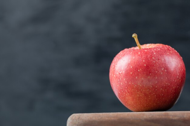 Manzanas aisladas sobre una tabla de cortar de madera rústica