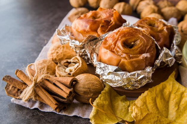 Manzanas al horno en papel de aluminio en un plato con nueces