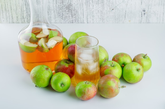 Manzanas con bebida vista de ángulo alto en blanco y sucio
