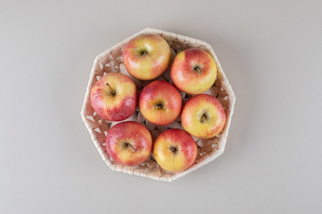 Manzanas en una canasta blanca sobre mármol