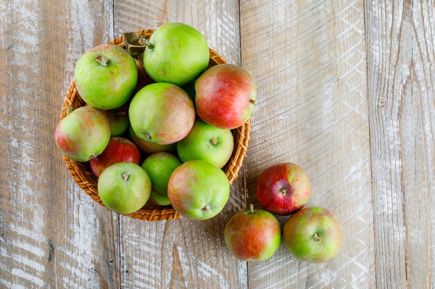 Manzanas en una canasta de mimbre sobre madera.