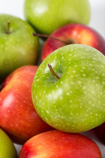 Manzanas coloridas frescas maduras suaves jugosas en un escritorio blanco