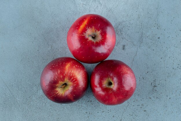 Manzanas dulces, rojas, sobre el fondo de mármol. Foto de alta calidad