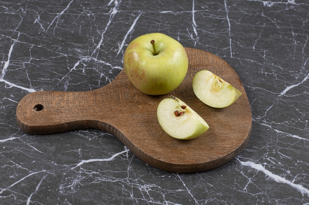 Foto gratuita manzanas enteras y en rodajas sobre tabla de madera.