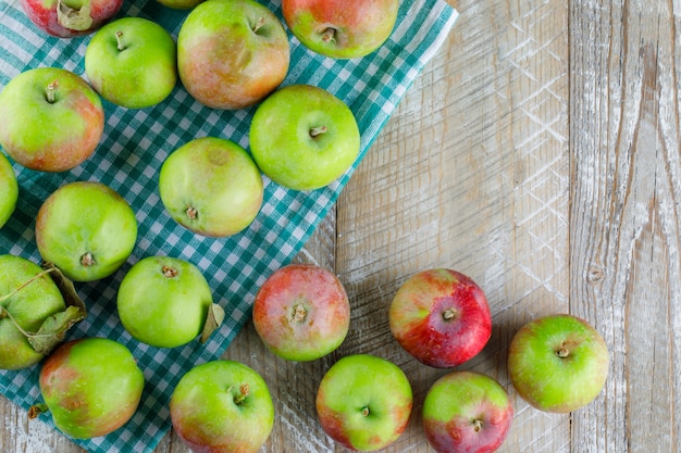 Foto gratuita manzanas esparcidas sobre tela de madera y picnic. endecha plana.