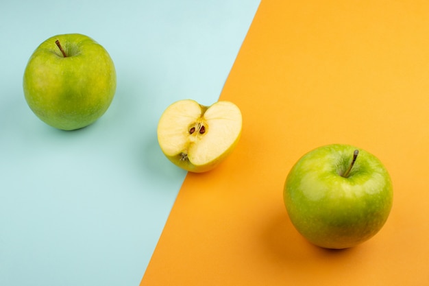 Manzanas frescas agridulces en el suelo naranja y azul hielo