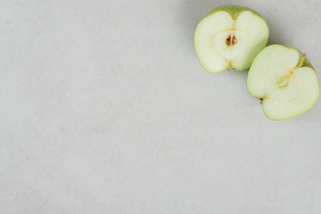 Manzanas frescas cortadas a la mitad en superficie gris