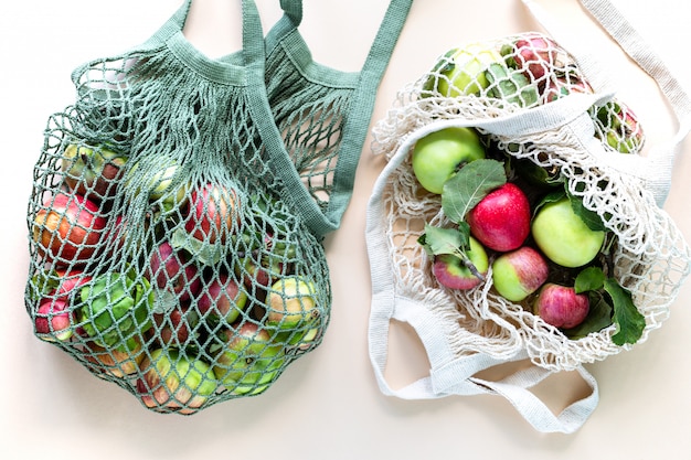 Manzanas frescas en una malla de bolsa de compras. Cero desperdicio, sin concepto de plástico. Una dieta sana y desintoxicante. Cosecha de otoño. Vista plana endecha, superior.