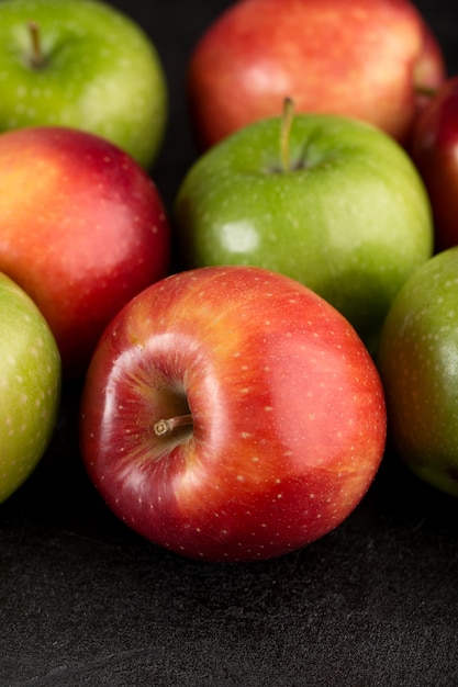 Manzanas frescas rojas y verdes frescas maduras suaves aisladas en el escritorio gris
