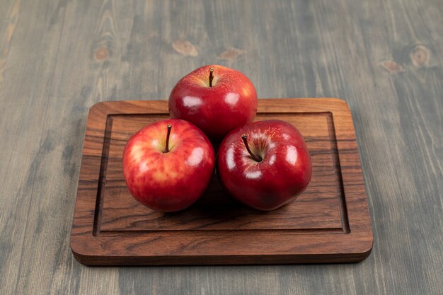 Manzanas jugosas en una tabla de cortar de madera. Foto de alta calidad