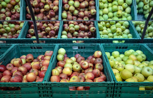 Manzanas naturales frescas en cajas en el mostrador del supermercado.