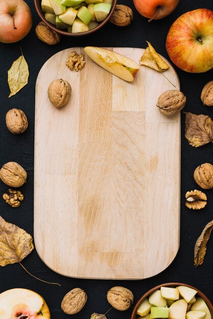 Manzanas y nueces alrededor de la tabla de cortar