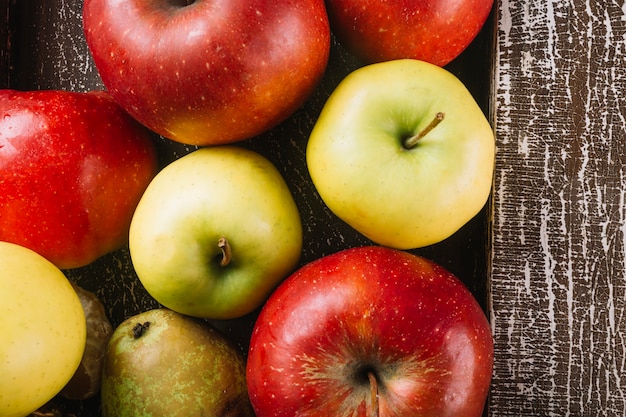 Foto gratuita manzanas y peras cerca de tablón de madera