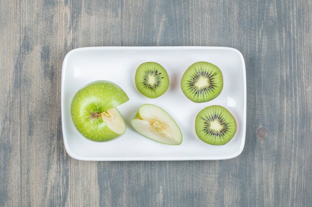 Manzanas en rodajas con kiwi fresco sobre una mesa de madera