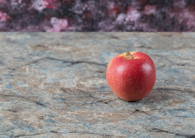 Manzanas rojas aisladas sobre una superficie de hormigón