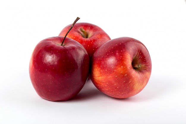 Manzanas rojas frescas suaves jugosas enteras perfectas en el escritorio blanco