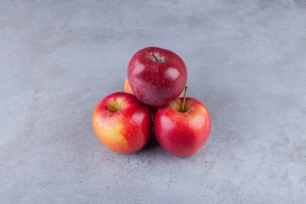 Manzanas rojas maduras colocadas sobre una mesa de piedra.