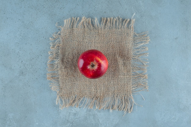 Manzanas rojas sobre una toalla, sobre el fondo de mármol. Foto de alta calidad