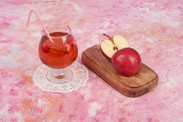 Manzanas rojas con un vaso de jugo.