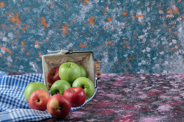 Foto gratuita manzanas rojas y verdes en una canasta rústica