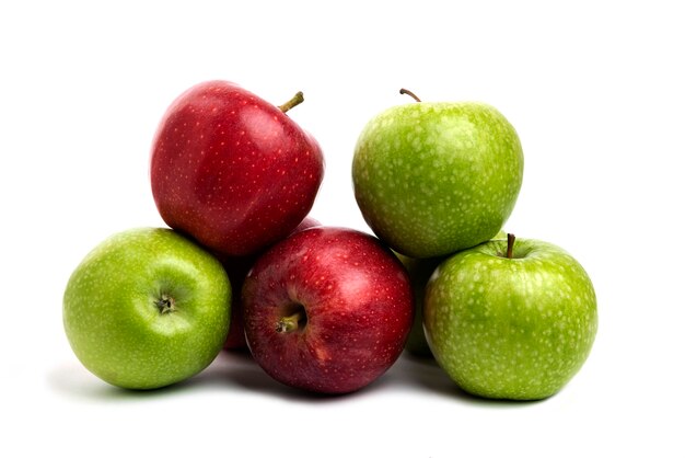 Manzanas rojas y verdes frescas aisladas en blanco.