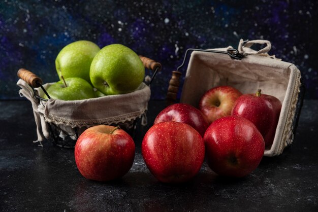 Manzanas rojas y verdes orgánicas maduras en cestas metálicas.