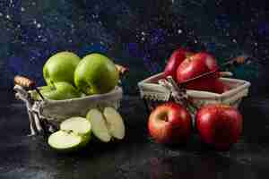 Foto gratuita manzanas rojas y verdes orgánicas maduras en cestas metálicas.