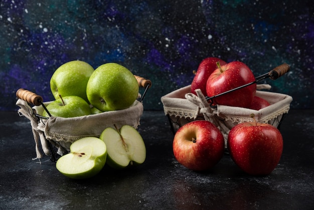 Manzanas rojas y verdes orgánicas maduras en cestas metálicas.