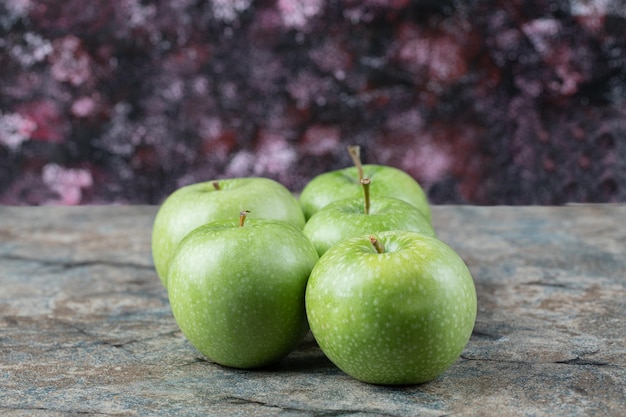 Manzanas verdes aisladas sobre hormigón.