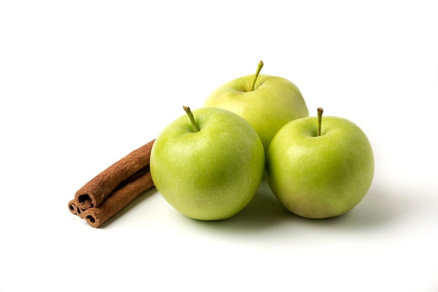 Manzanas verdes y canela aislado en blanco