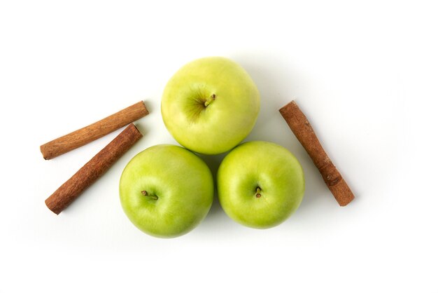 Manzanas verdes y canela aislado en blanco