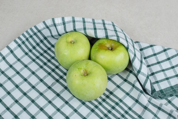 Manzanas verdes enteras sobre mantel rayado