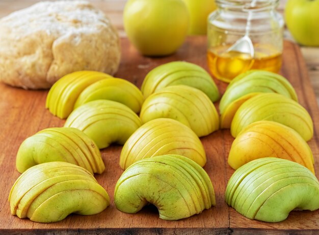 Manzanas verdes frescas cortadas en rodajas sobre una tabla de madera