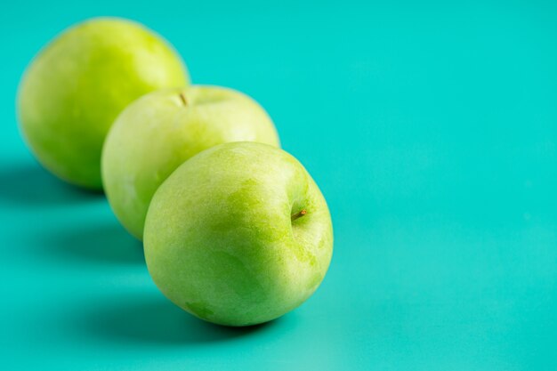 Manzanas verdes frescas puestas sobre fondo verde claro