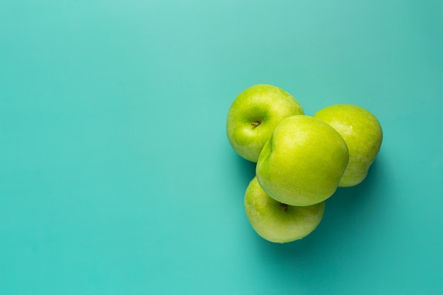 Manzanas verdes frescas puestas sobre fondo verde claro