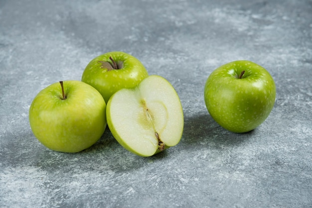 Manzanas verdes frescas sobre fondo de mármol.