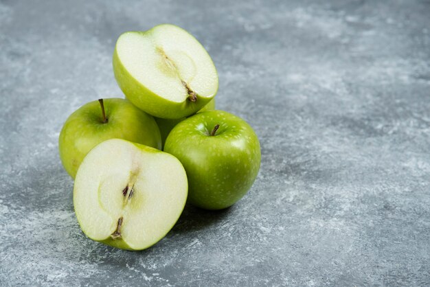 Manzanas verdes frescas sobre fondo de mármol.