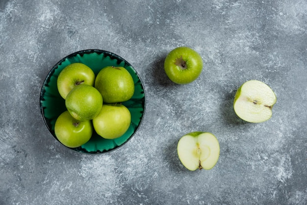 Manzanas verdes frescas en un tazón verde.