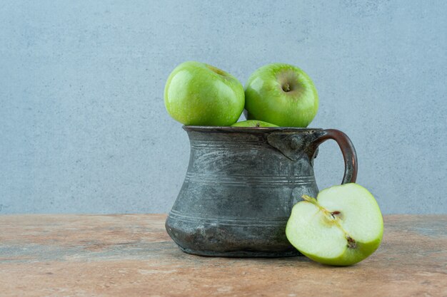 Manzanas verdes en un plato de hierro.