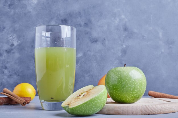 Manzanas verdes con un vaso de jugo.