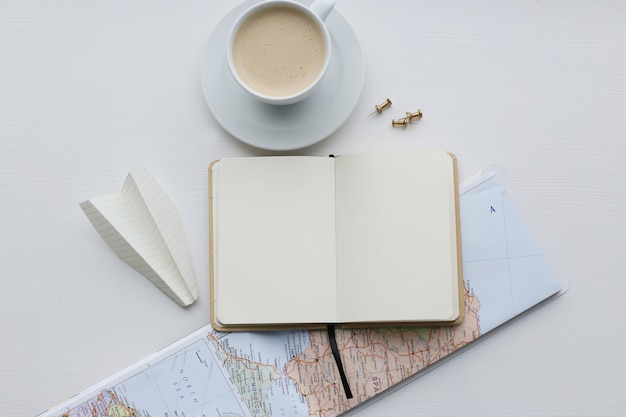 Mapa de viaje, diario y taza de café.