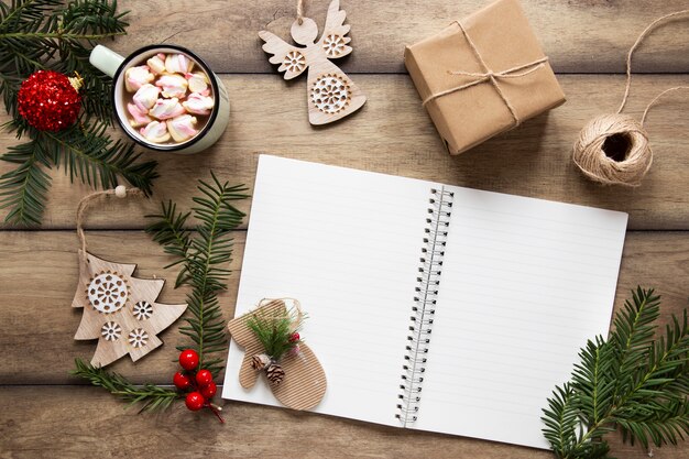 Maqueta de cuaderno rodeada de adornos navideños