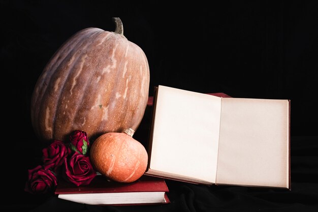 Maqueta de libro con calabazas y rosas