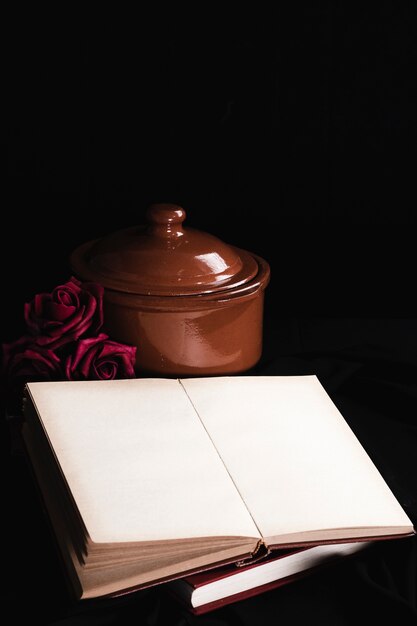 Maqueta de libro con rosas y maceta marrón