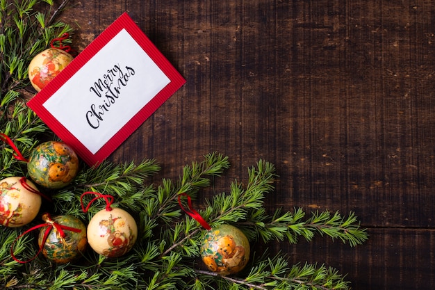 Maqueta de tarjeta de Navidad con adornos sobre fondo de madera